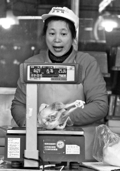 超市售貨員正在對雞肉稱重