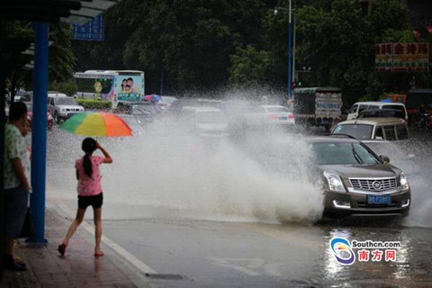 7月21日，廣州下起雷暴雨，暴雨造成不少低洼地區(qū)水淹，圖為廣州大道北一低洼處，一輛行駛而過的車輛濺起了近三米高的水花，一旁的行人紛紛躲避。（南方日報(bào)記者 郭智軍 攝）